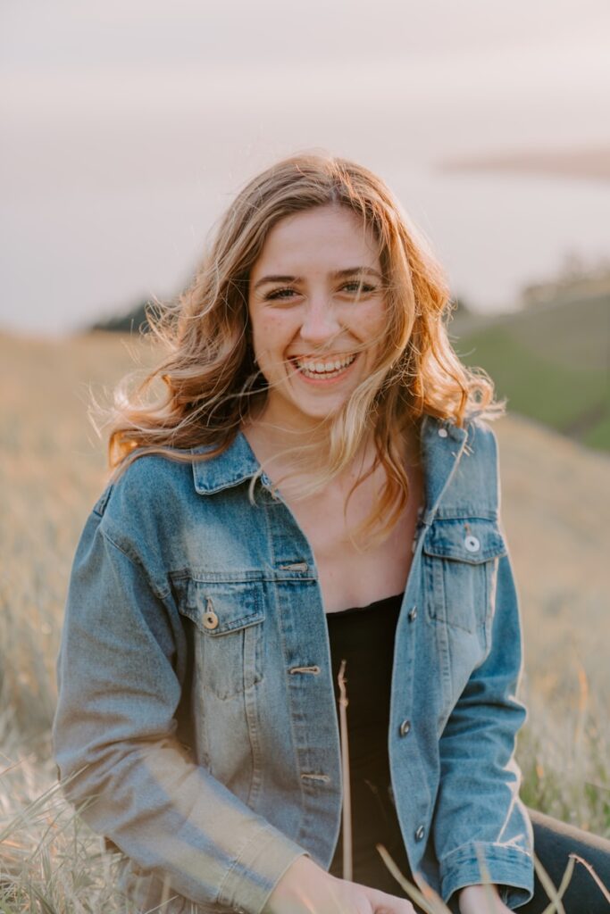 Photo by Slav Romanov smiling woman sitting on grass during daytime